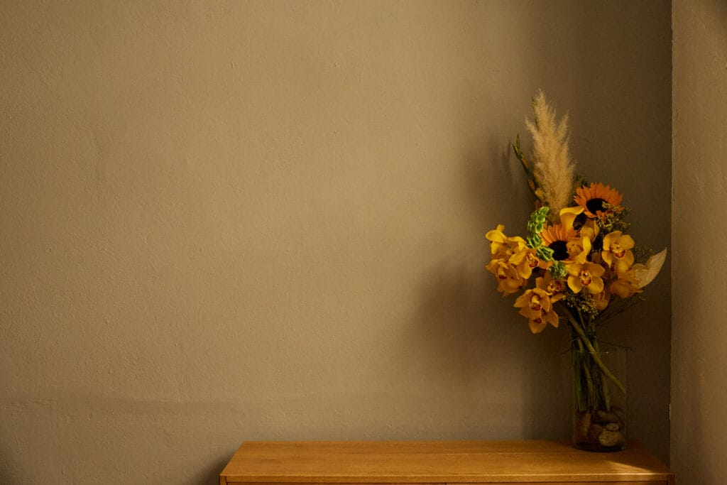 Gelber Blumenstrauß am Holztisch, Life Coaching.