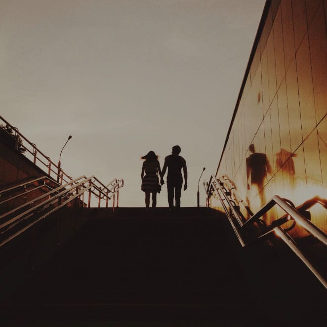 Pärchen, das Hände haltend die Treppe hochläuft